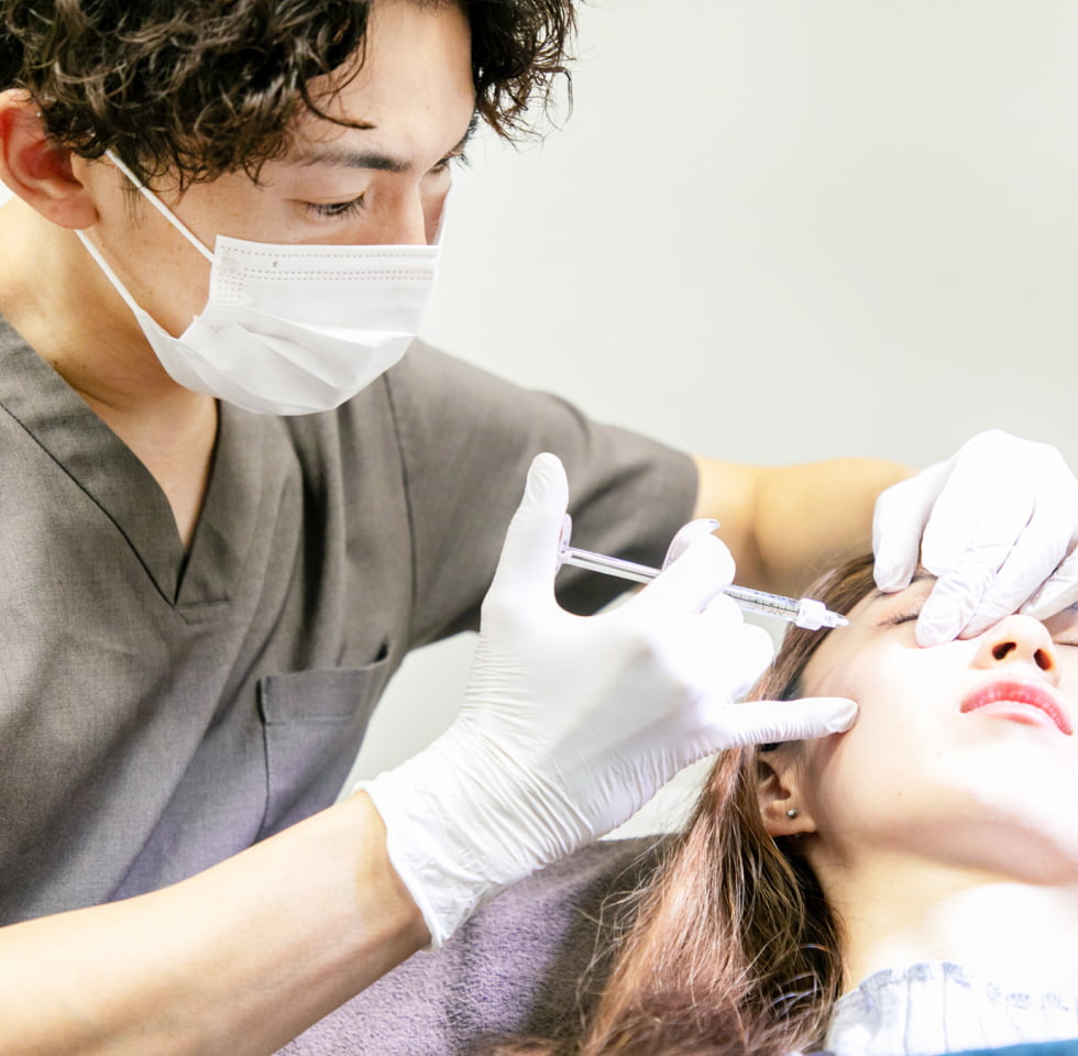 施術中の写真 目元に注射針を刺している