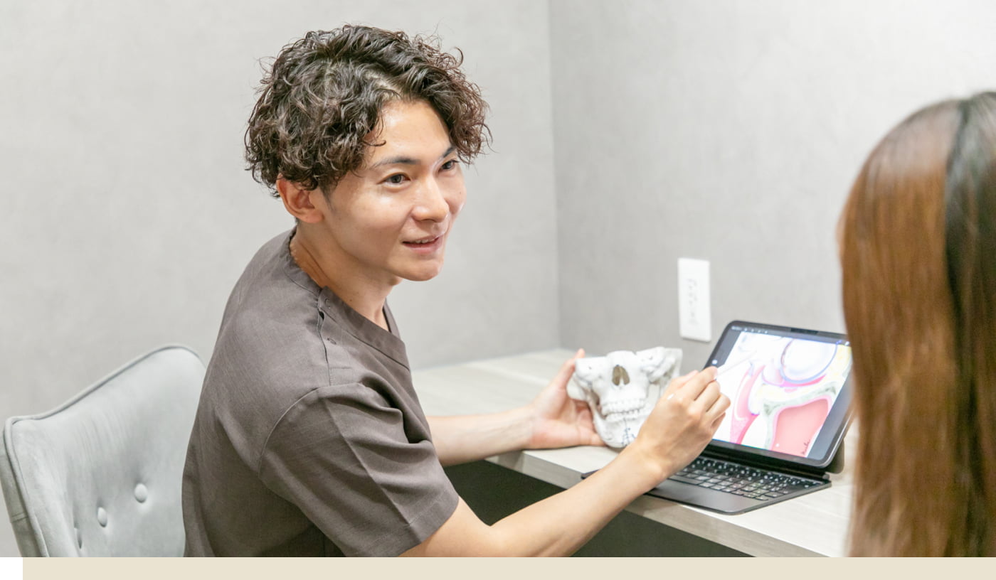 カウンセリングの写真 タブレットと模型を用いながら説明している